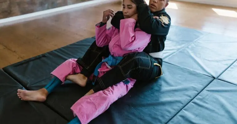 A Jiu-Jitsu practitioner establishing back control with hooks on their partner, showcasing essential submission-ready BJJ positions for beginners.