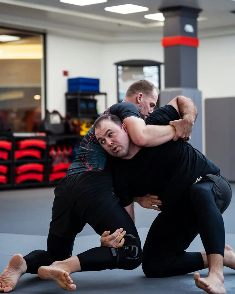 Two athletes drilling takedowns during BJJ basics practice