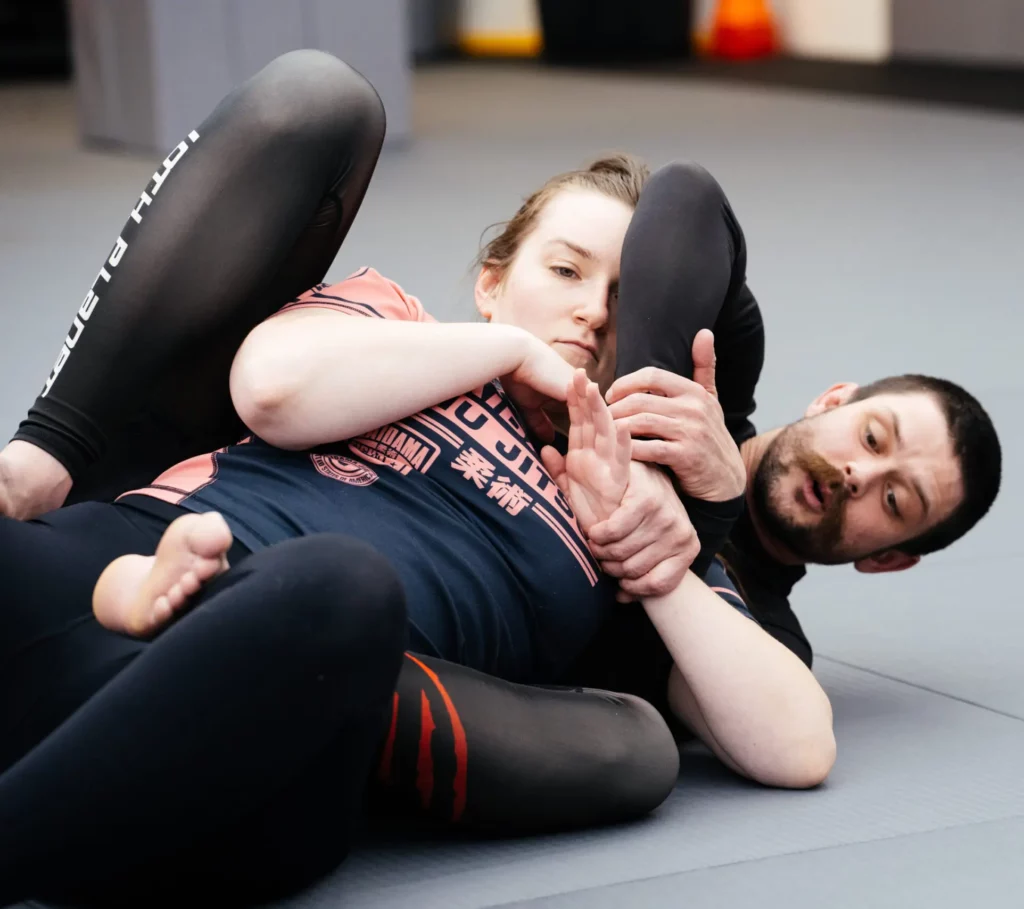 Instructor demonstrating leg control during a first BJJ class