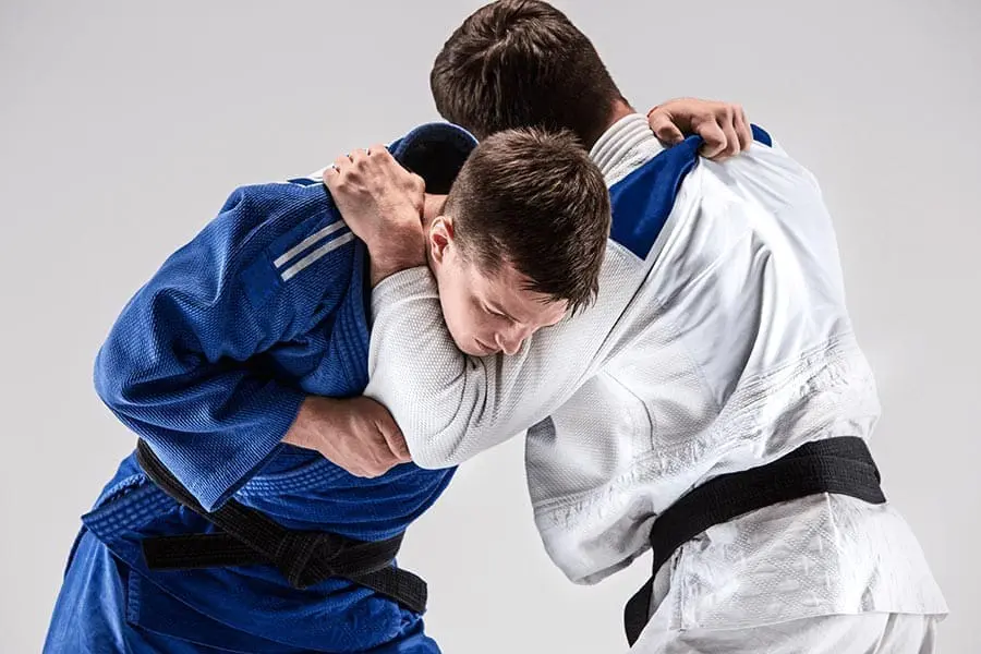 Two partners hand fighting while practicing BJJ basics