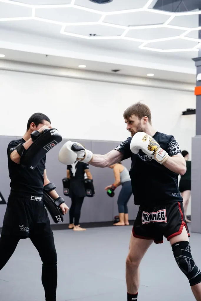 Student throwing jab into pads during Muay Thai training