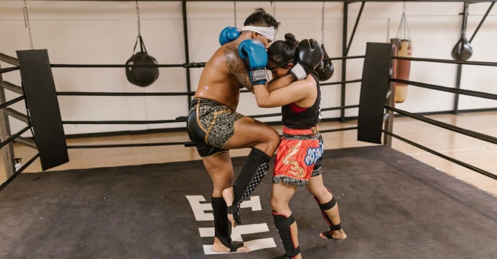 Partners drilling clinch knees for Muay Thai defense practice